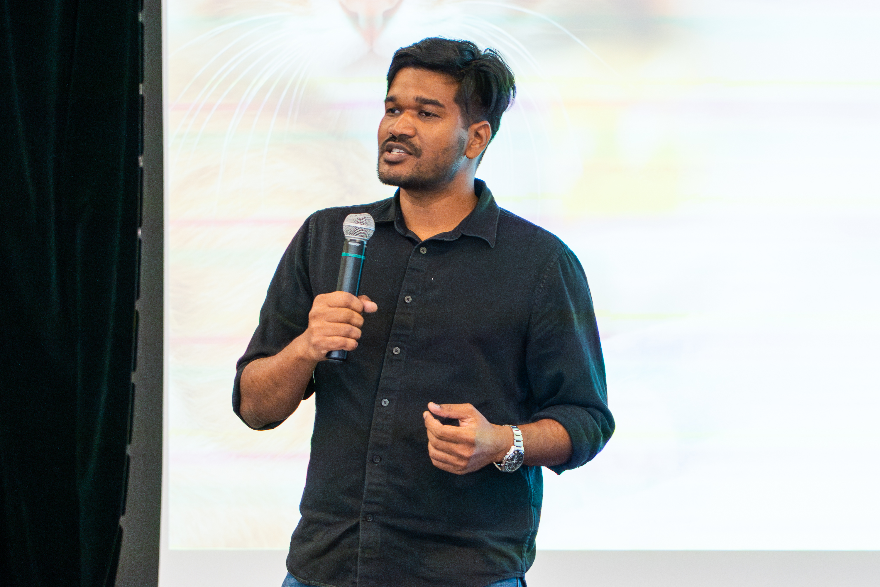 Picture of Amar Kumar on stage giving his presentation