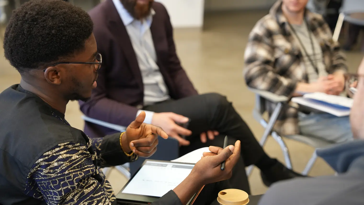 a young man asking question on a round table activity