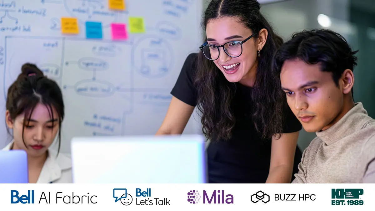 trois personnes qui travaillent sur un ordinateur avec des notes sur un tableau blanc derrière eux