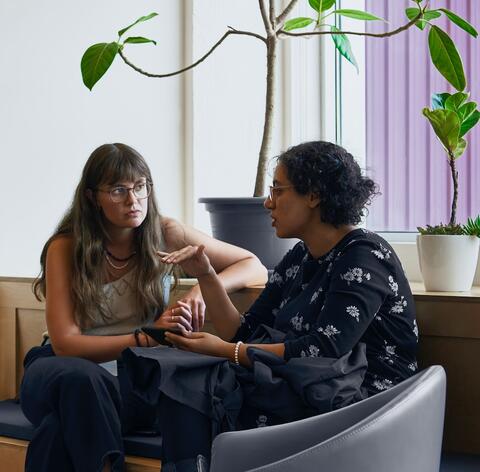 Deux femmes discutent dans un espace commun à Mila. 