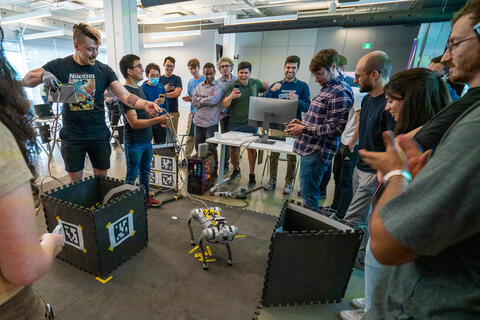 Des participants à l'école d'été en robotique essayant de déplacer un robot