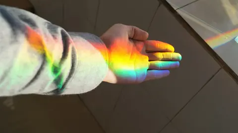 Hand bathed in natural rainbow light. 