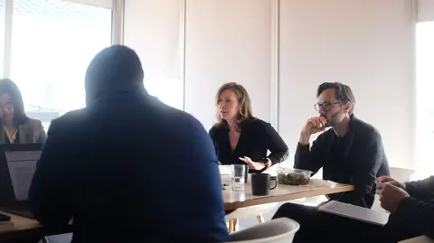 People talking in a meeting room. 