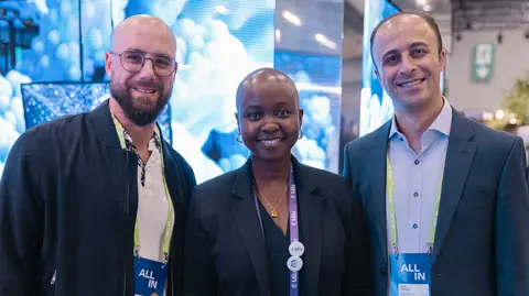 Two men and a woman posing for a photo. 