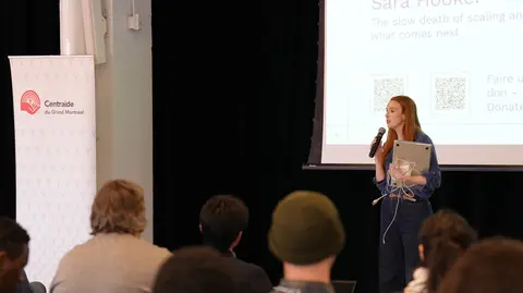 A woman speaking in front of an audience. 