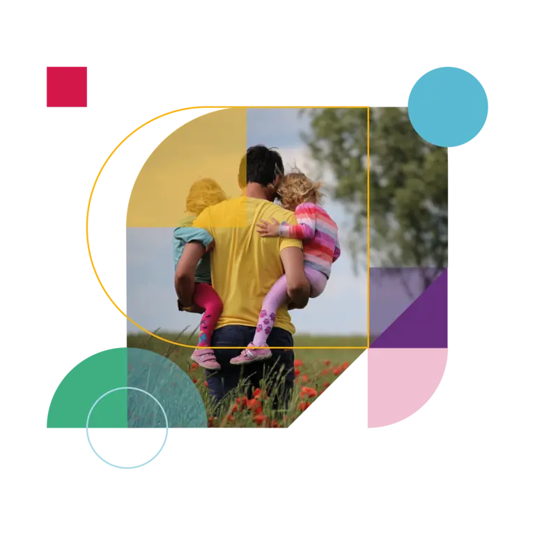 Man holding his two daughters in a field of red-petaled flowers.