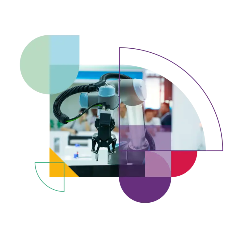 People watch a robotic arm at work in a factory.