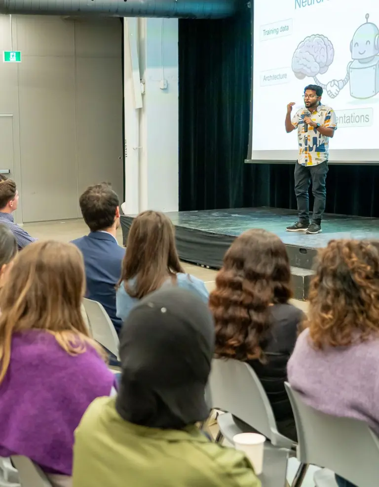 Un public écoute un participant du concours Science Éclair sur scène.