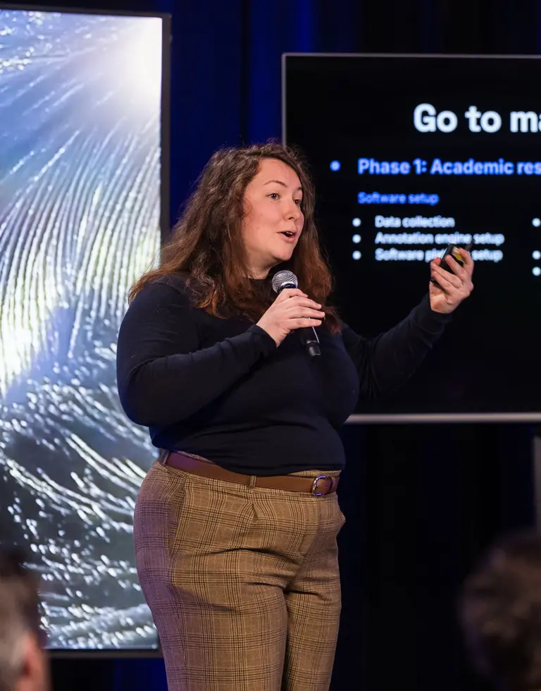 Picture of Ayssa, a participant of the Mila Startup Challenge, presenting her startup on stage