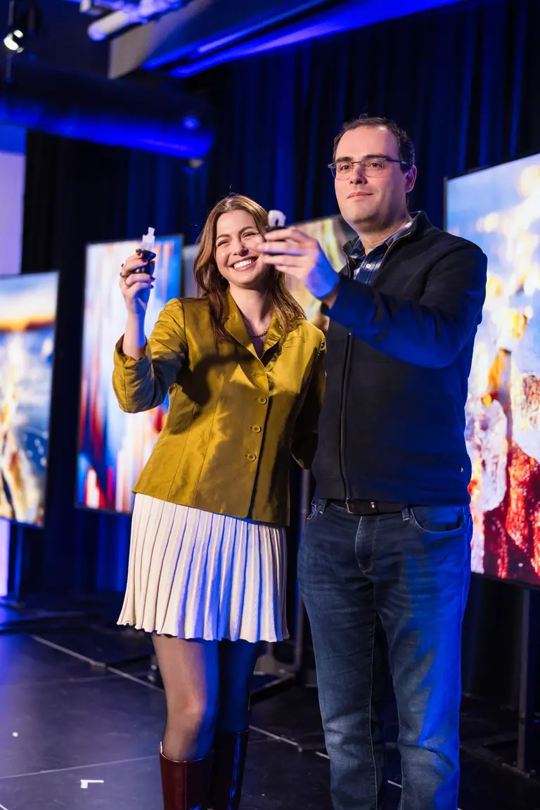A young women and young man standing on stage and holding a 3D ring as a trophy