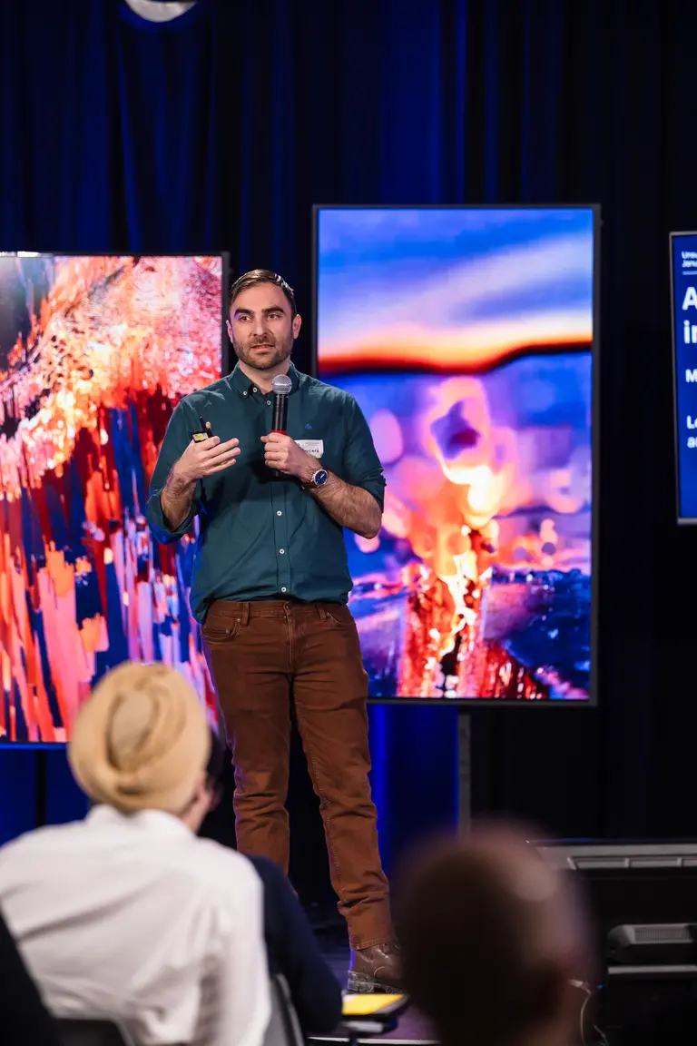 Picture of Glen Berseth on stage pitching his startups