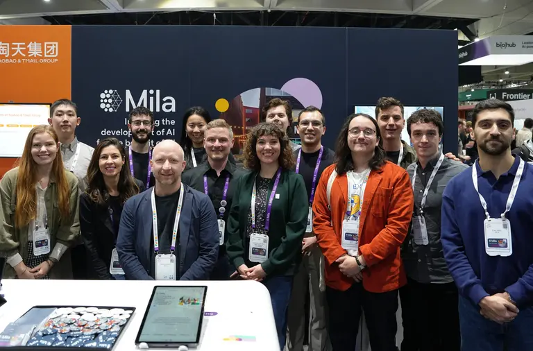Picture of Mila delegation in front of Mila Booth at NeurIPS 2025