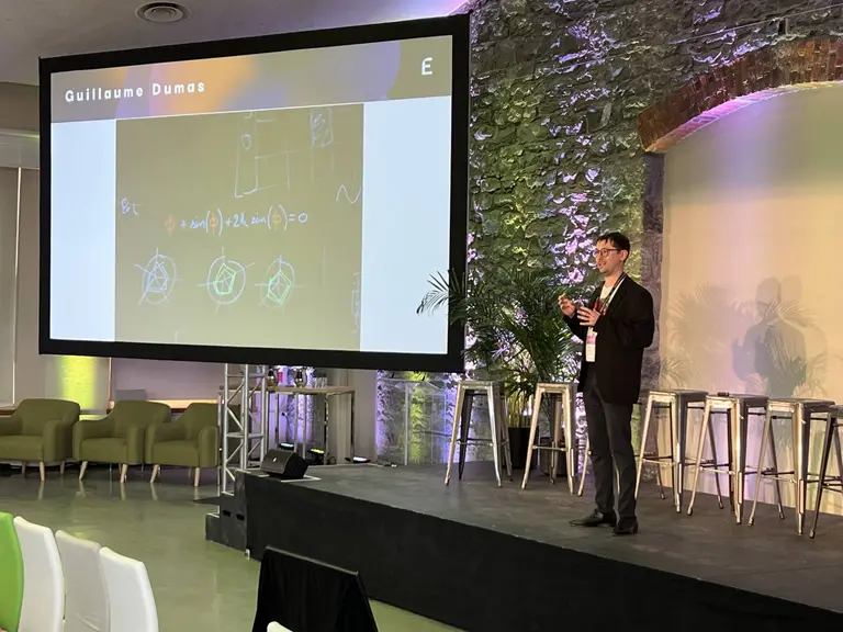 Picture of Guillaume Dumas on stage making a presentation