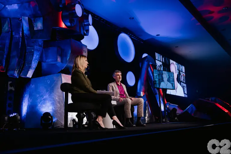 Yoshua Bengio on stage during C2 Montreal discussing with Yuval Noah Harari online
