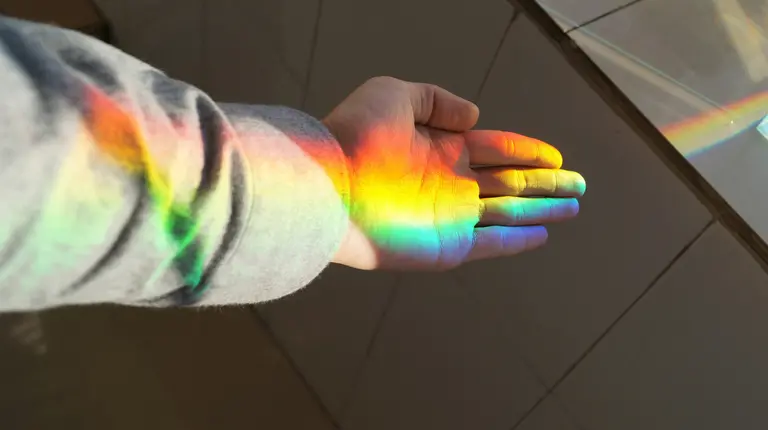 Main baignée dans la lumière naturelle de l'arc-en-ciel. 