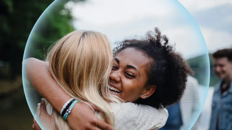 Two women hugging each other. 