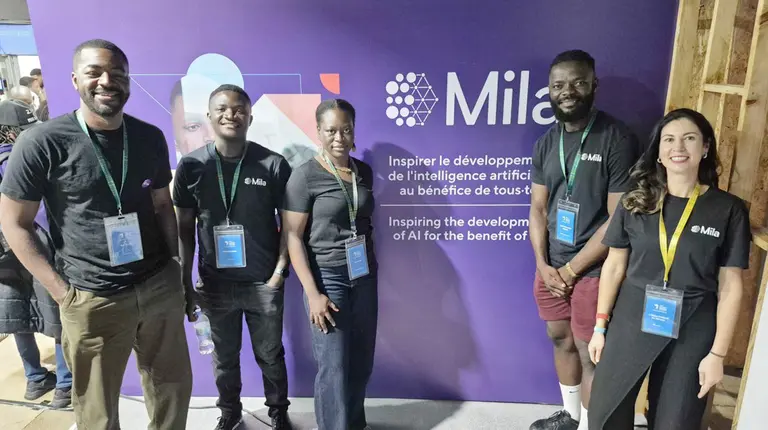 Un groupe de personnes posant devant le kiosque de Mila à Indaba 2025.