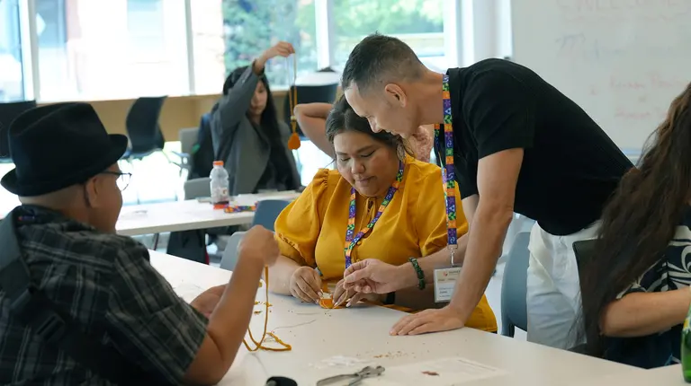 Une femme autochtone participant à une activité de perlage.