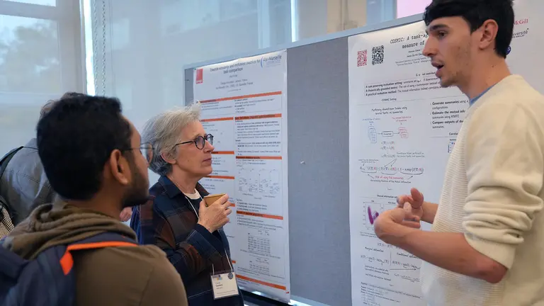 A student presenting his work at a conference poster session.