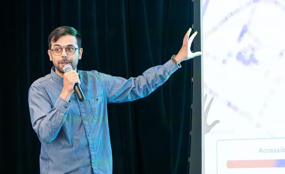 Picture of Rashid Mushkani presenting his work in front of an audience during speed science contest