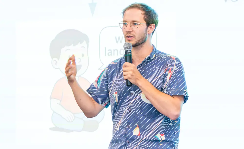 Picture of Benno Krojer presenting his work in front of an audience during speed science contest