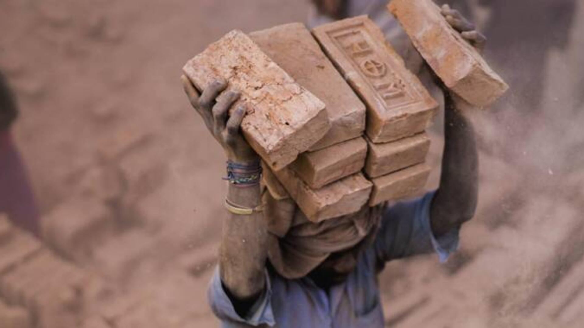 A man transporting heavy bricks.