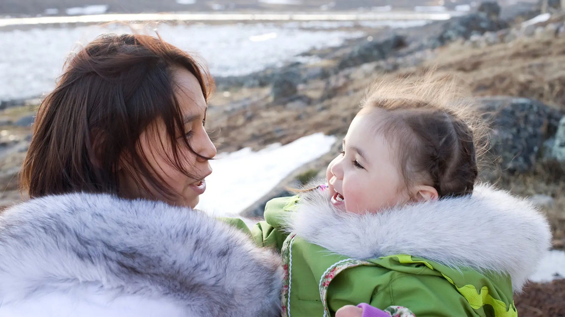 An Indigenous woman talking to her daughter. 