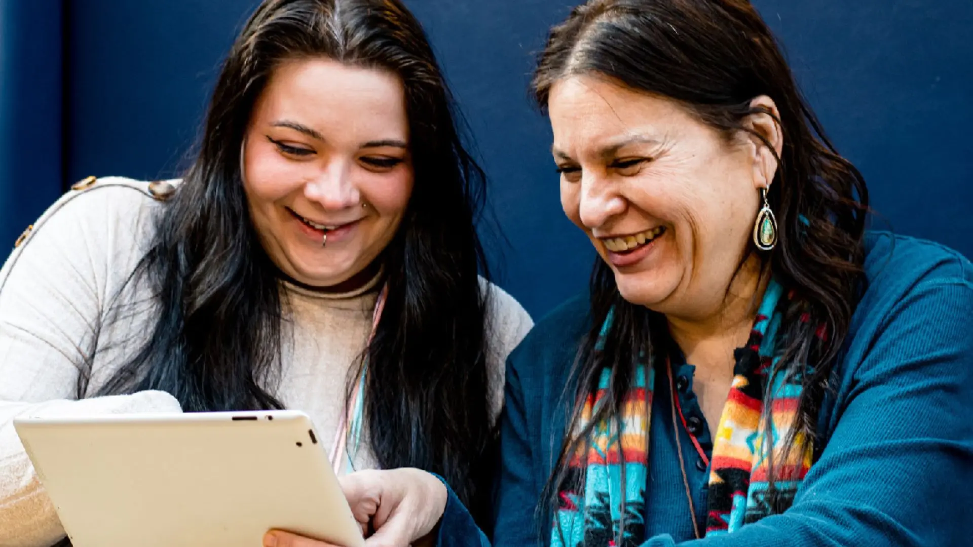 Une photo de deux femmes qui consultent un ipad pour une demande de bourse