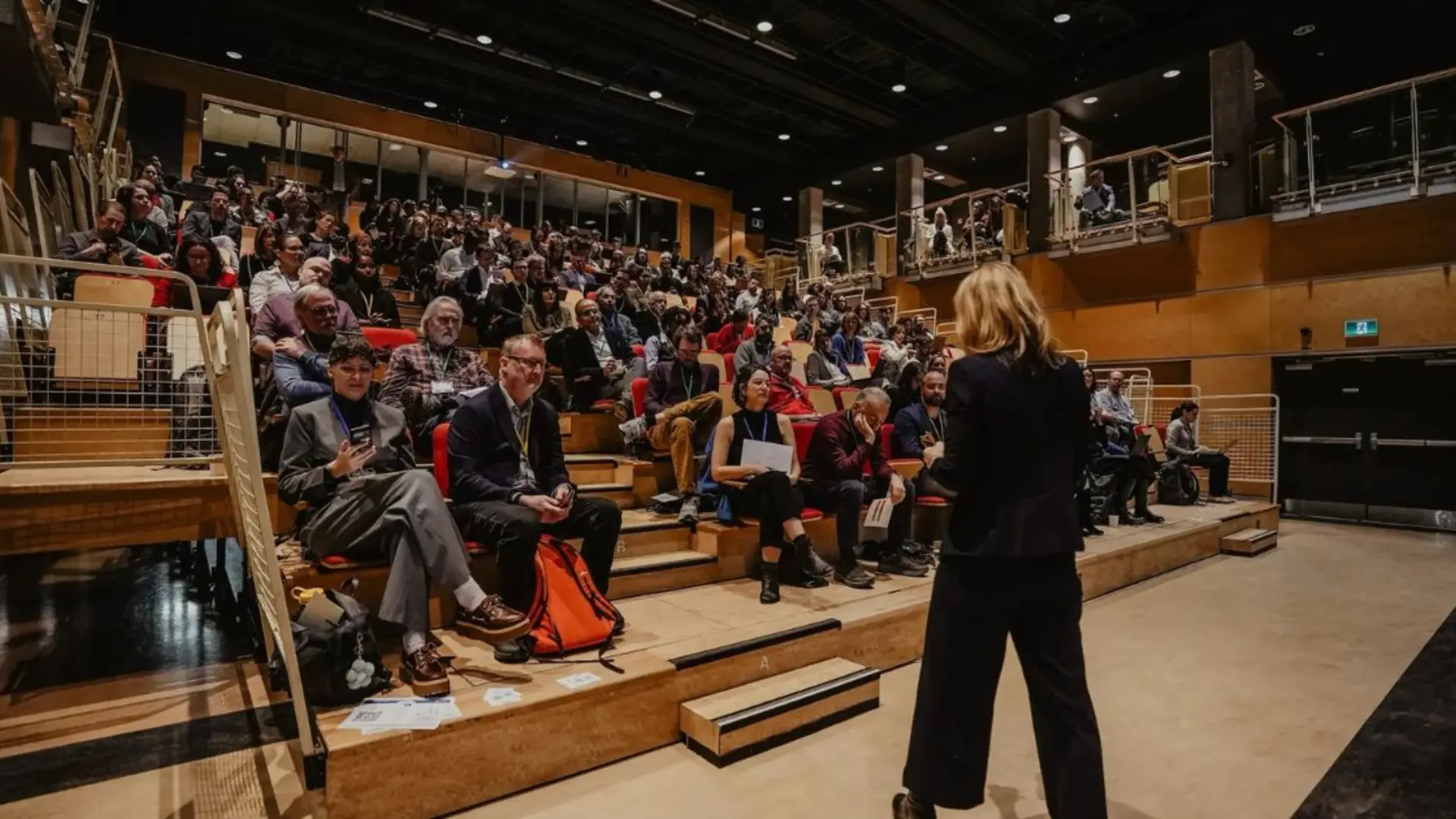 Women on stage while an auditorium is full of participants