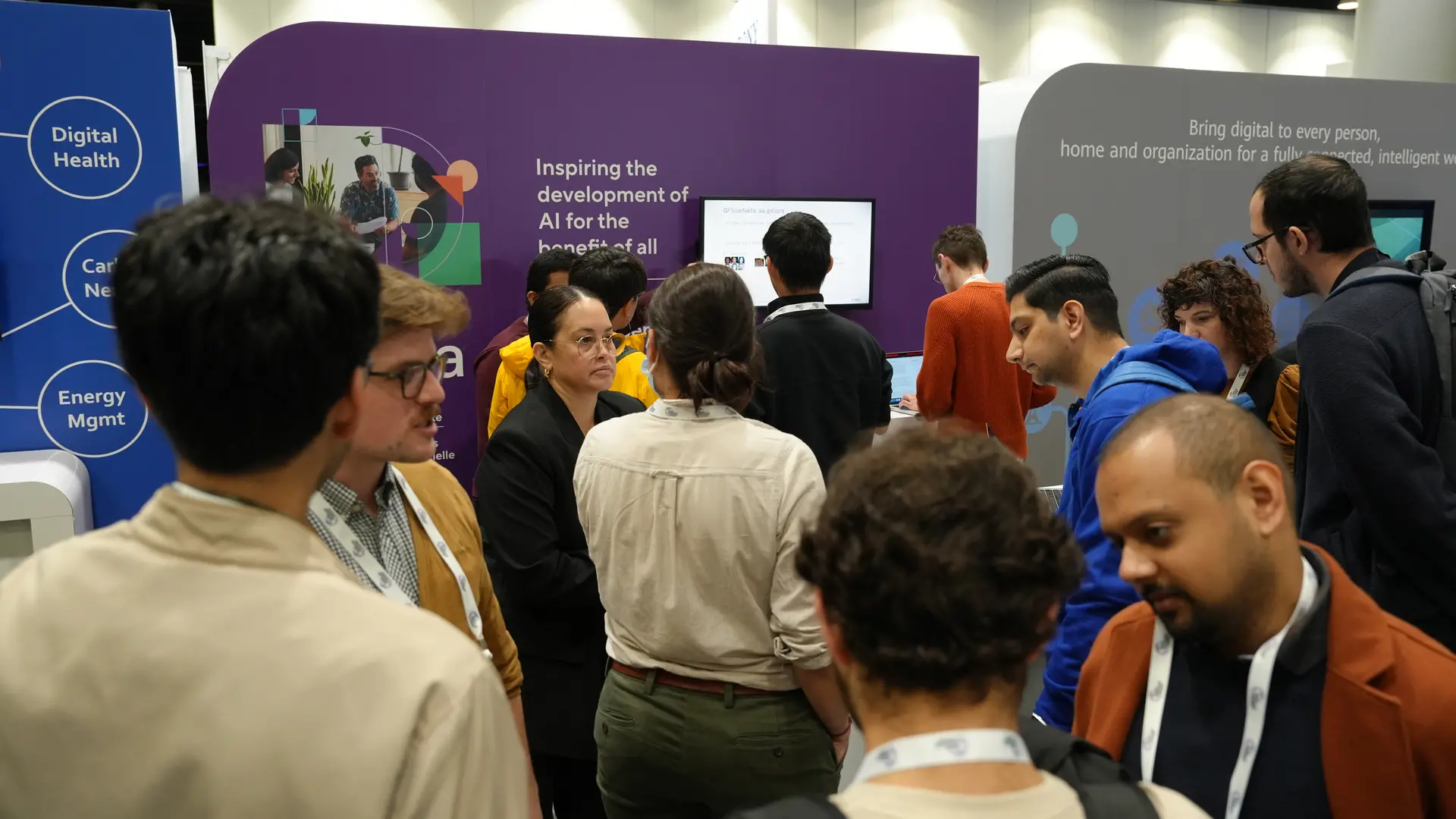 Personnel et étudiants de Mila au stand de Mila pendant NeurIPS