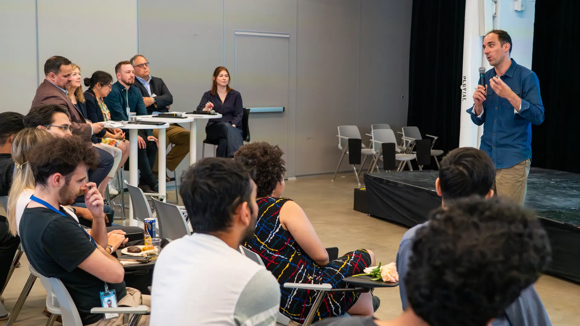 Picture of Laurent charlin on stage explains the evening's activities to the audience.