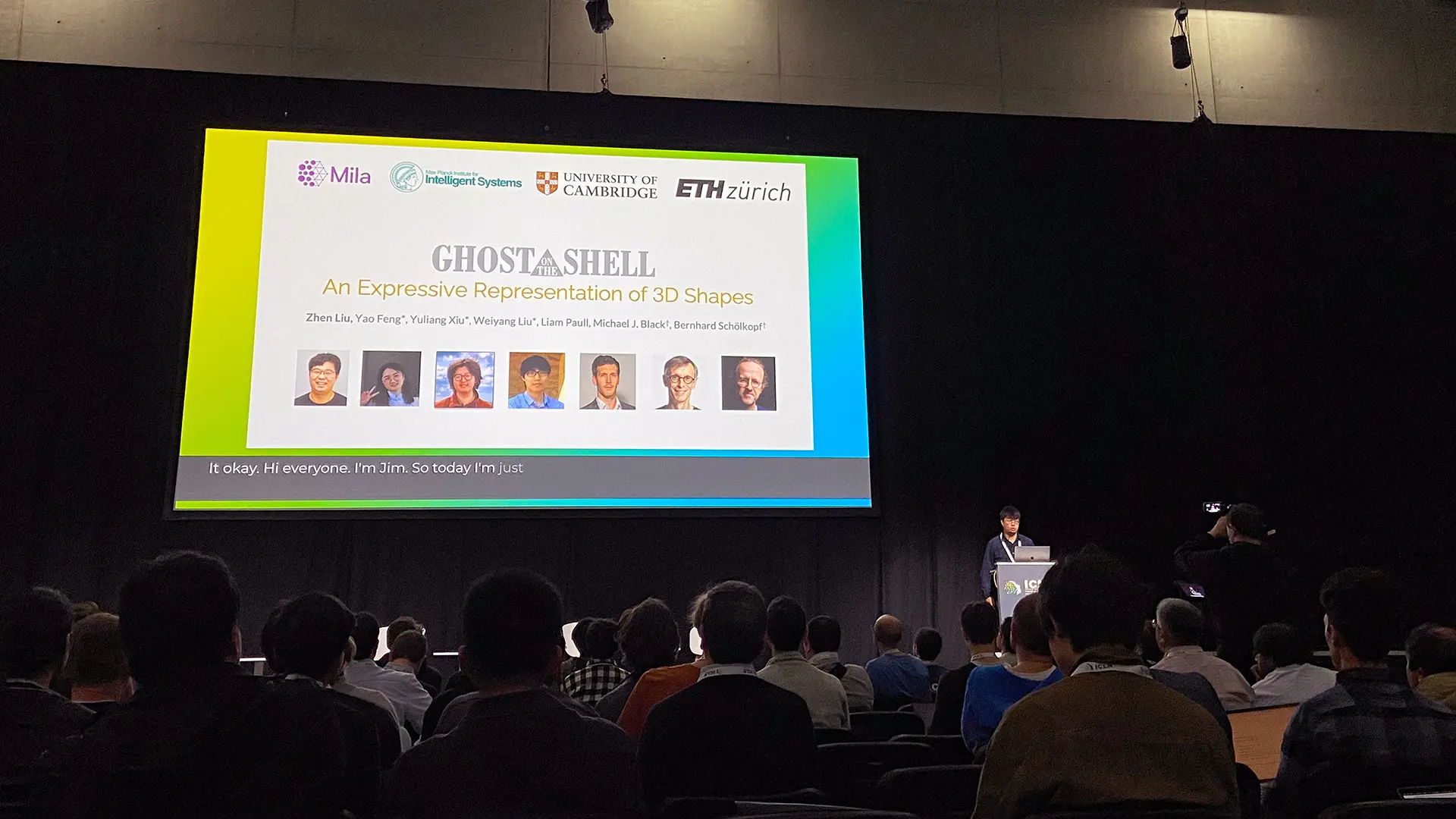 A person presenting in front of an audience at a conference. 