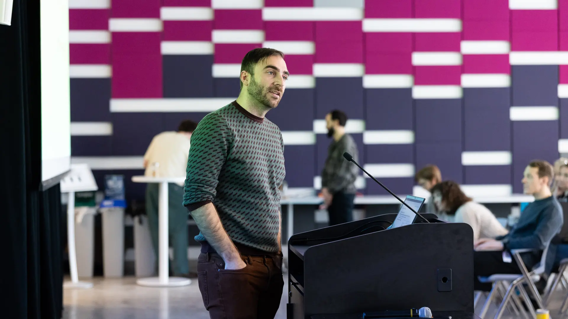 Photo de Glen Berseth présentant son travail de recherche devant une audience