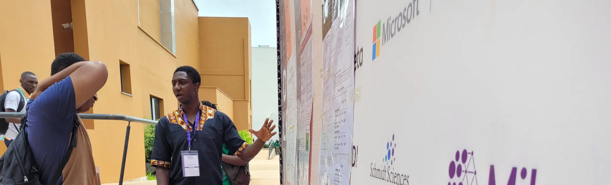 Mila researcher presenting his paper to a participant during poster session at a scientific conference