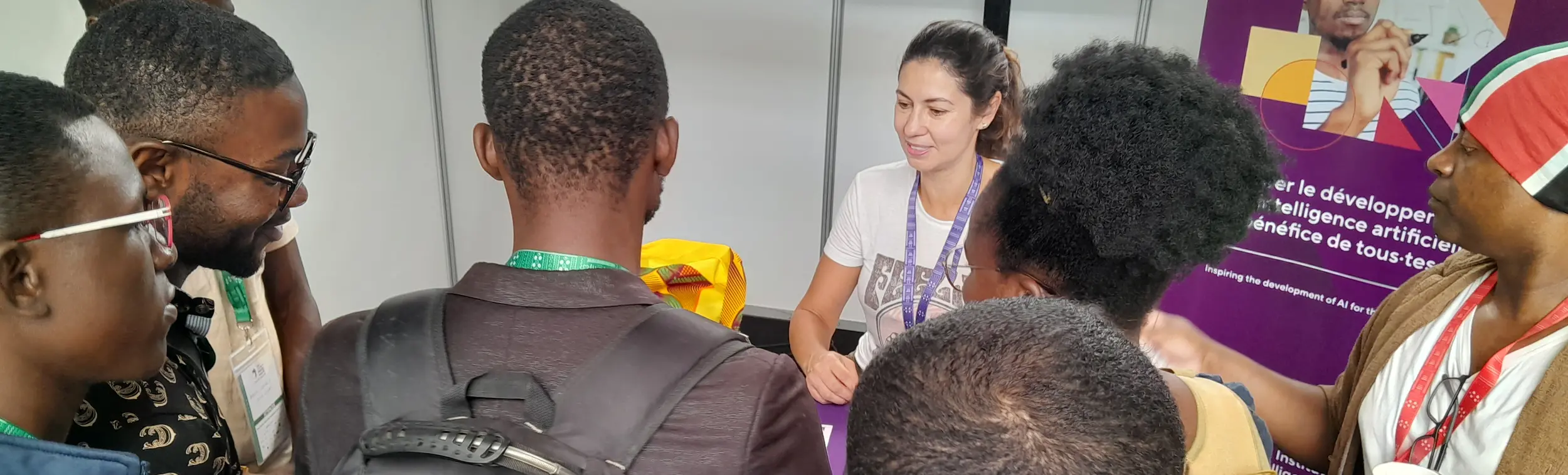 A Mila representative at the booth welcoming participants during a scientific event