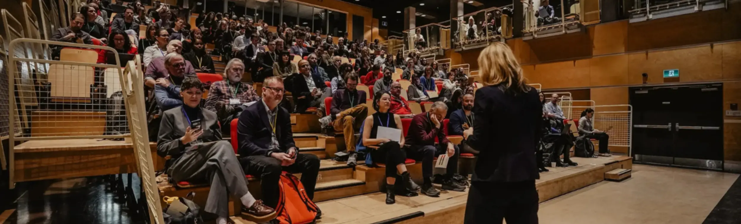 Picture of a women on stage while the auditorium is full