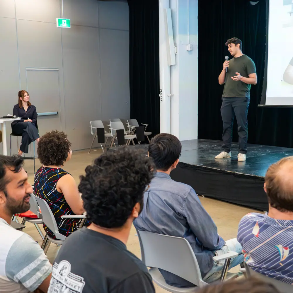 un participant au concours de vulgarisation scientifique de Mila sur scène en train de faire sa présentation