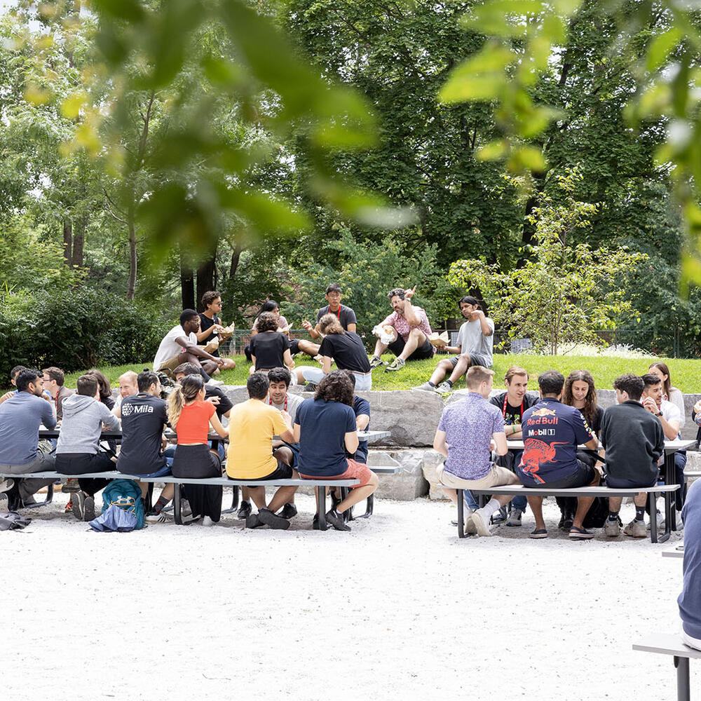 一群学生聚集在野餐桌旁。 