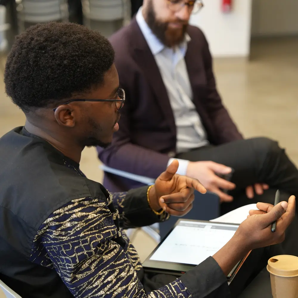 a young man talking with other participants during a round table activity