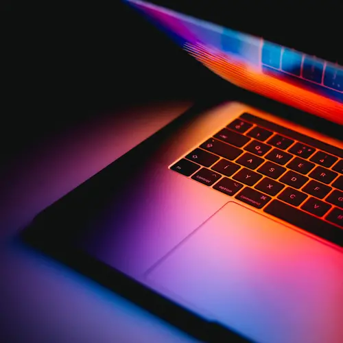 picture of an opened laptop with a red and purple background color
