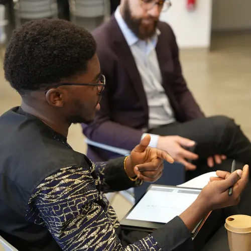 a young man talking with other participants during a round table activity