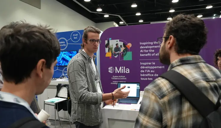 a Mila student researcher presenting his paper at Mila booth during NeurIPS 2024 Conference