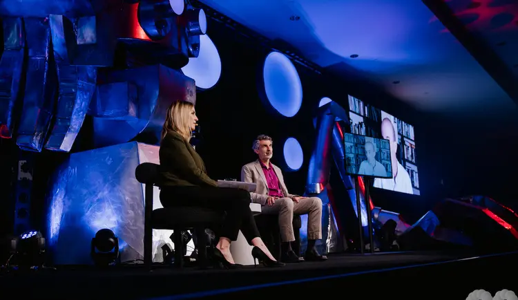 Yoshua Bengio on stage during C2 Montreal discussing with Yuval Noah Harari online