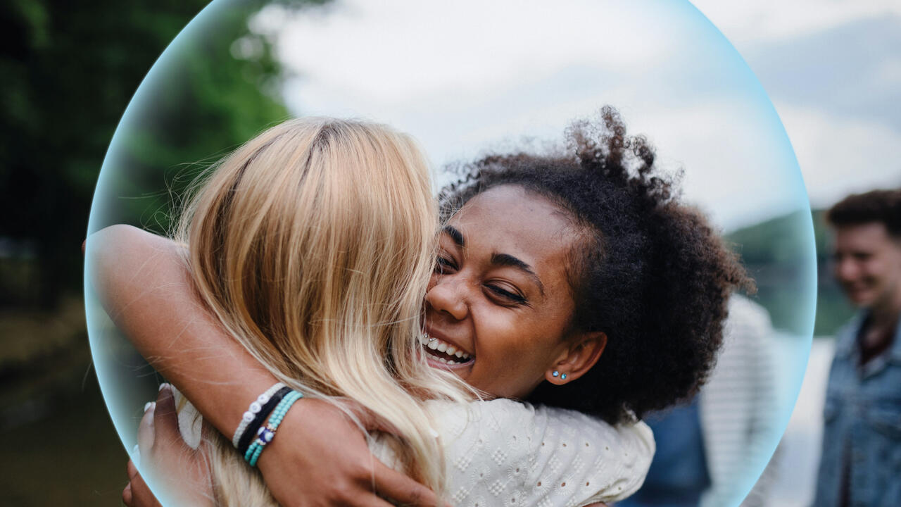 Two women hugging each other. 